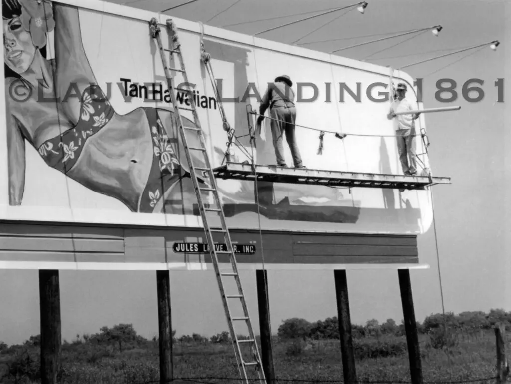 Two men painting an advertisement on the billboard